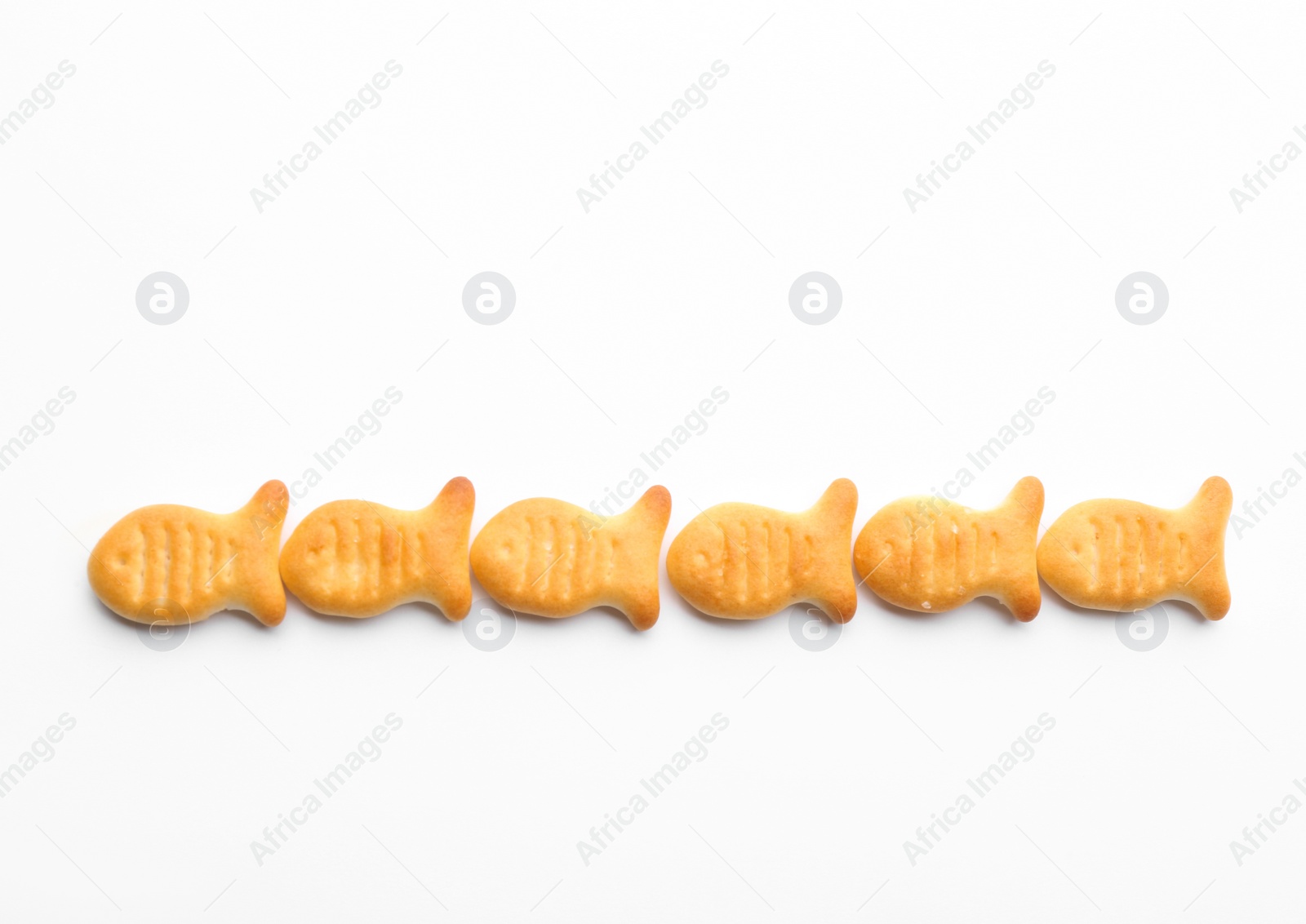 Photo of Delicious crispy goldfish crackers on white background, top view