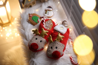 Photo of Sweets in soft slippers on windowsill, above view. Saint Nicholas Day tradition