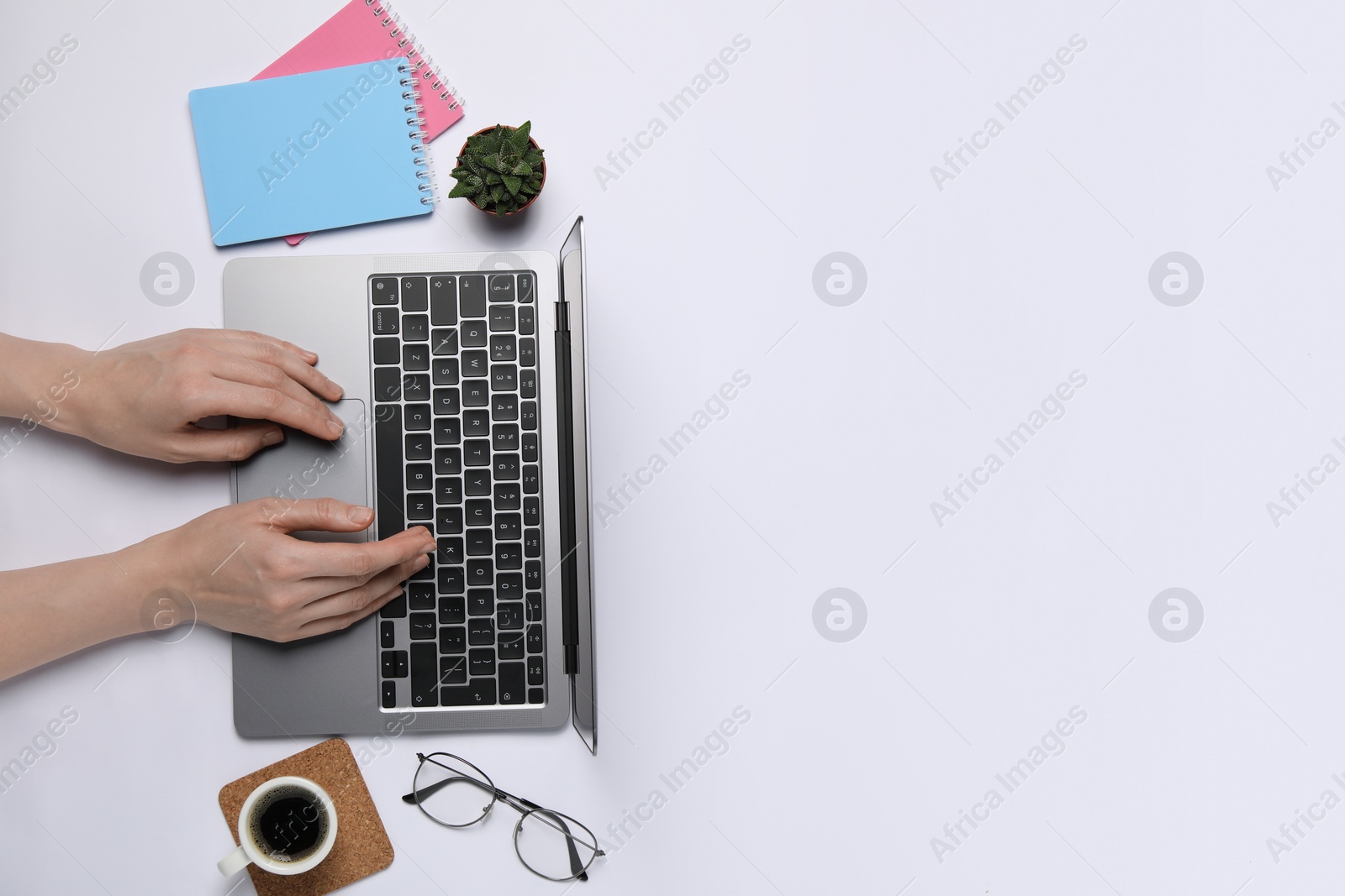 Photo of Woman using laptop at white table, top view. Space for text