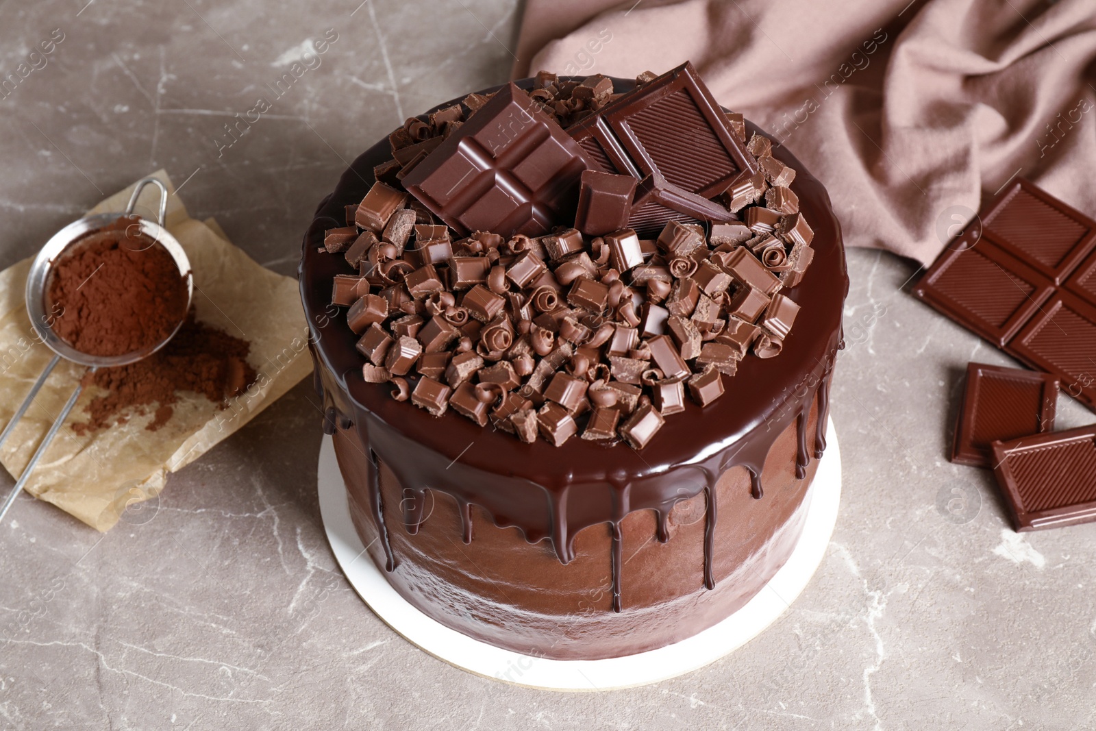 Photo of Freshly made delicious chocolate cake on marble table against grey background