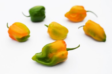 Different fresh raw hot chili peppers on white background, closeup
