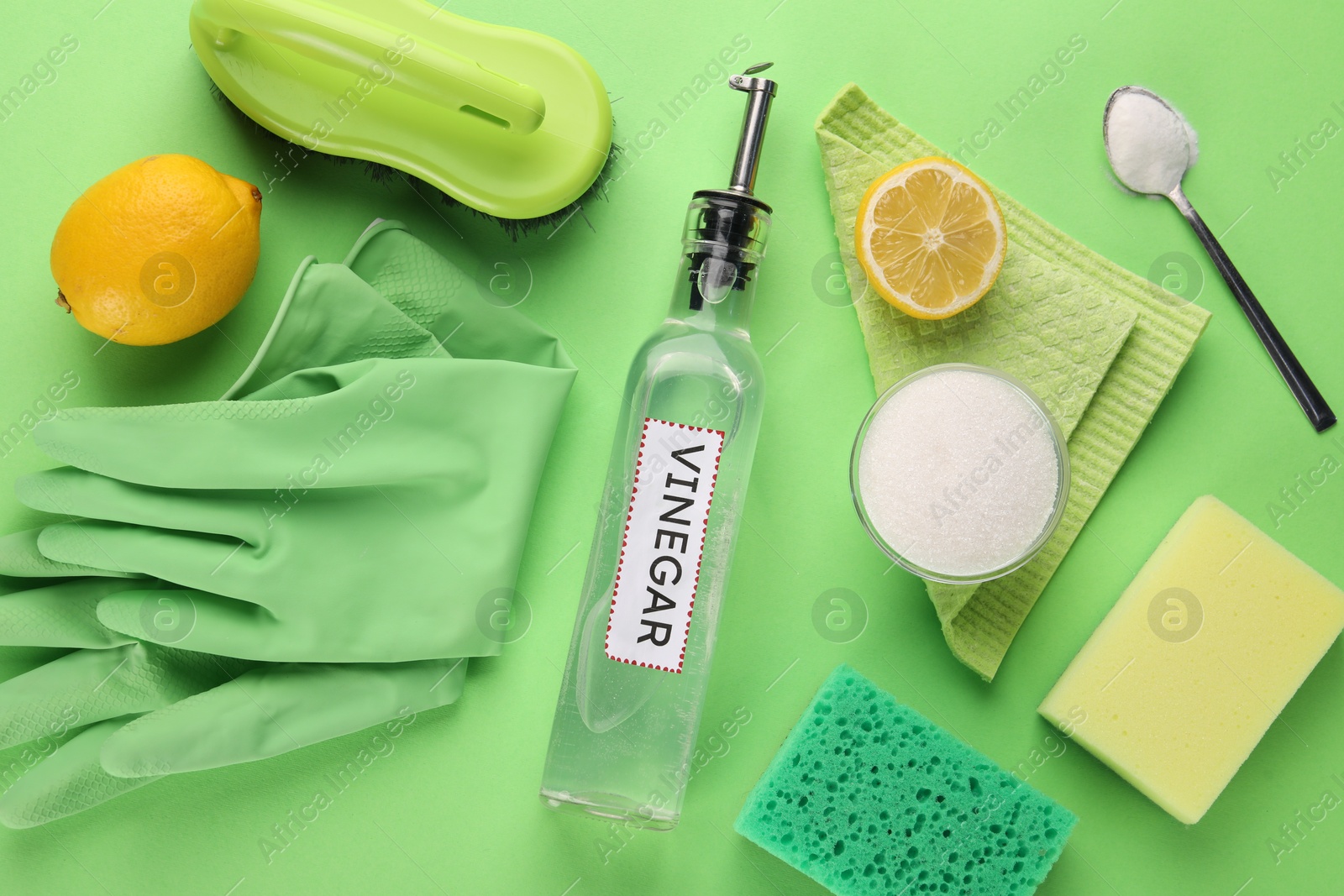 Photo of Eco friendly natural cleaners. Flat lay composition with bottle of vinegar on green background