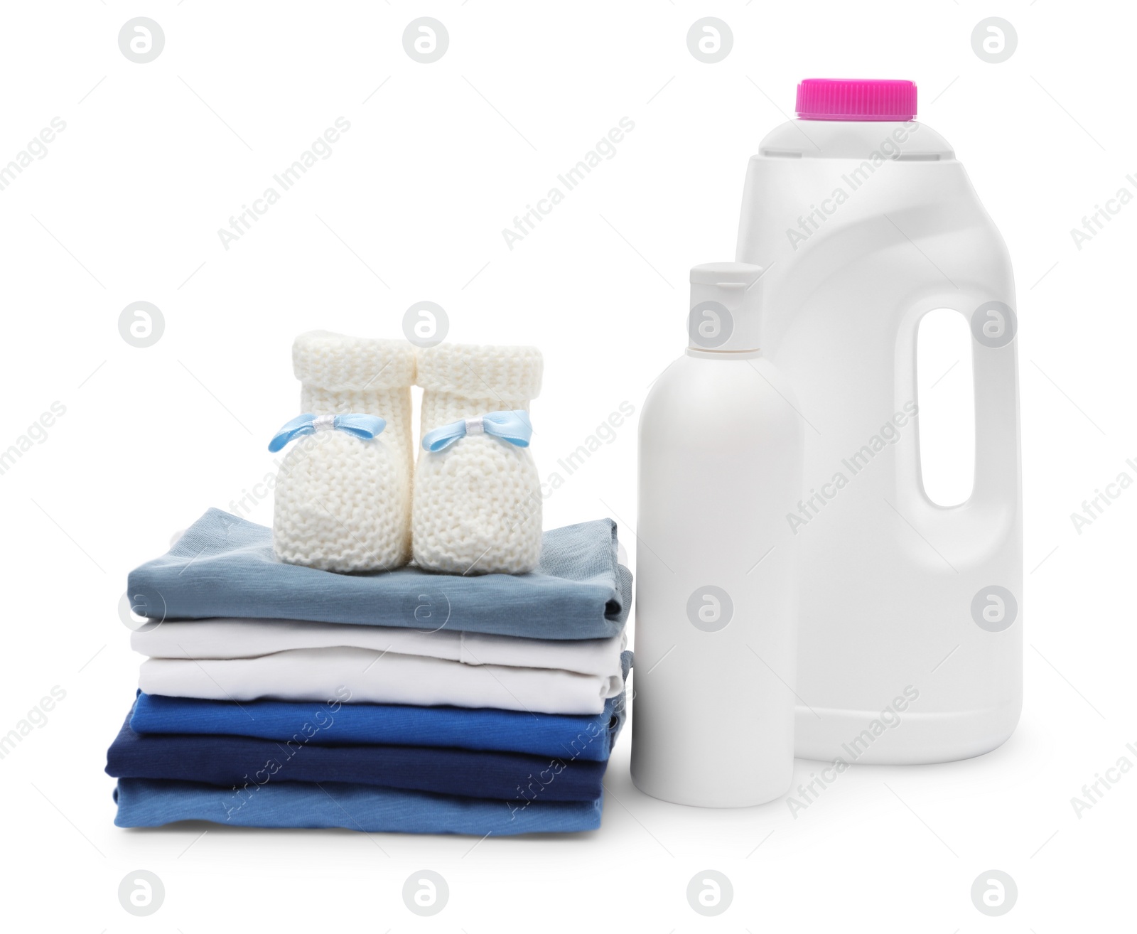 Photo of Laundry detergents, stack of baby clothes and small booties isolated on white