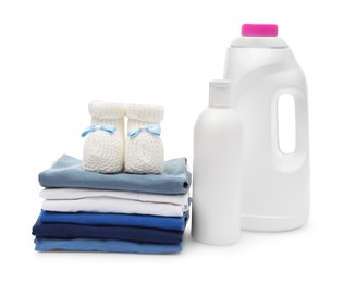 Photo of Laundry detergents, stack of baby clothes and small booties isolated on white