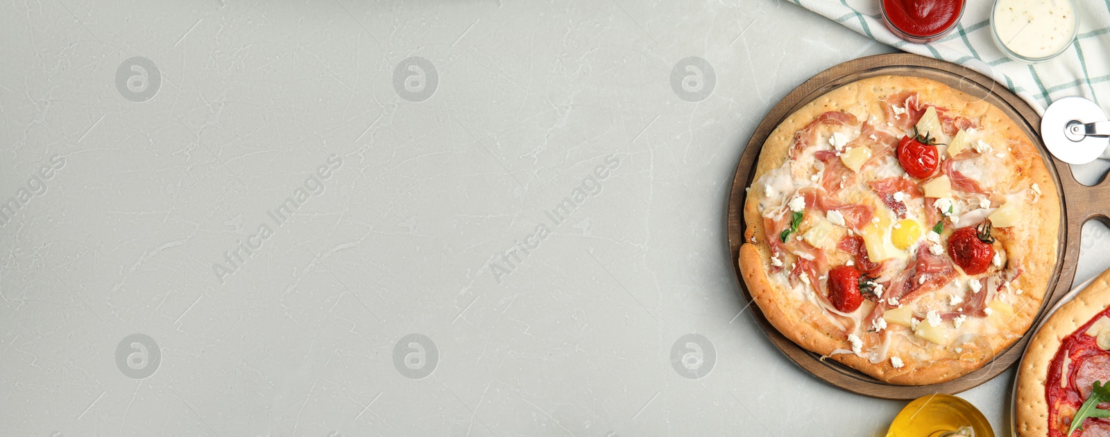 Image of Delicious homemade pita pizza on light marble table, flat lay with space for text. Banner design