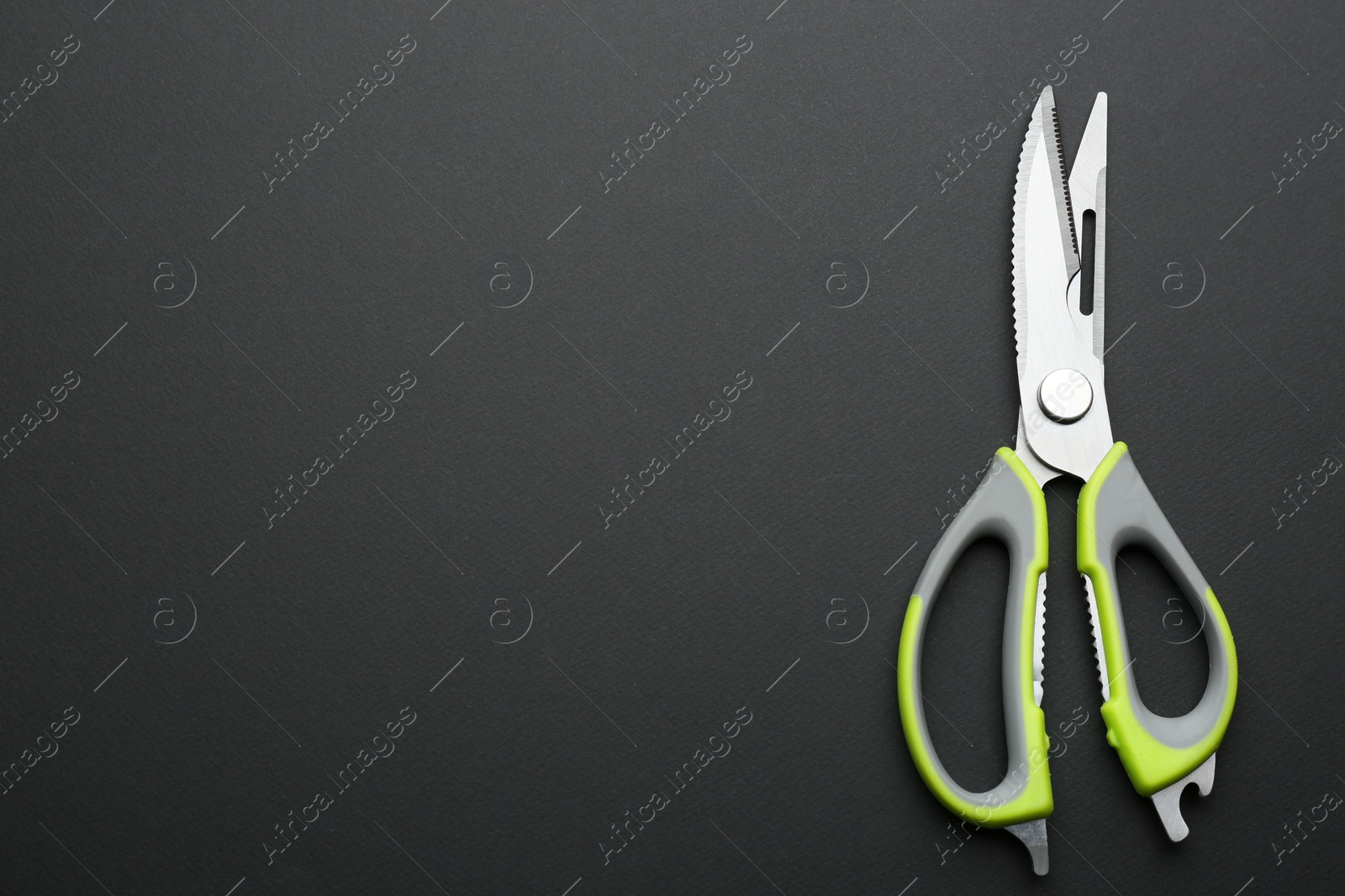 Photo of Kitchen scissors on dark background, top view. Space for text