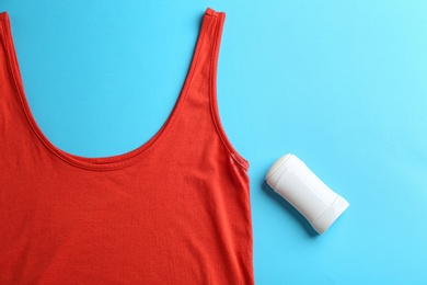 Photo of Clothes with stain and deodorant on light blue background, top view