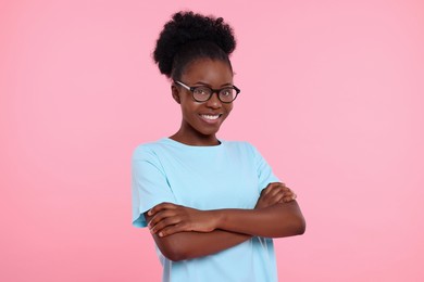 Photo of Portrait of happy young woman in eyeglasses on pink background
