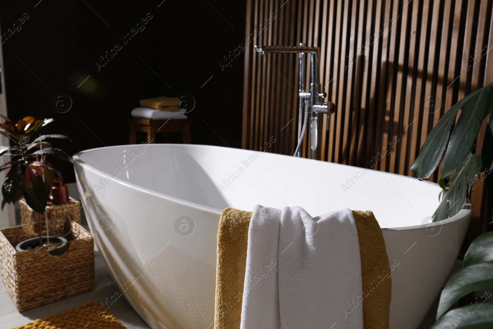 Photo of Cozy bathroom interior with stylish ceramic tub