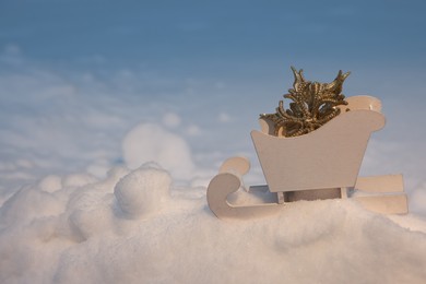 Photo of White wooden sleigh with decorative snowflake outdoors. Space for text