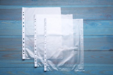 Photo of Punched pockets on light blue wooden table, flat lay