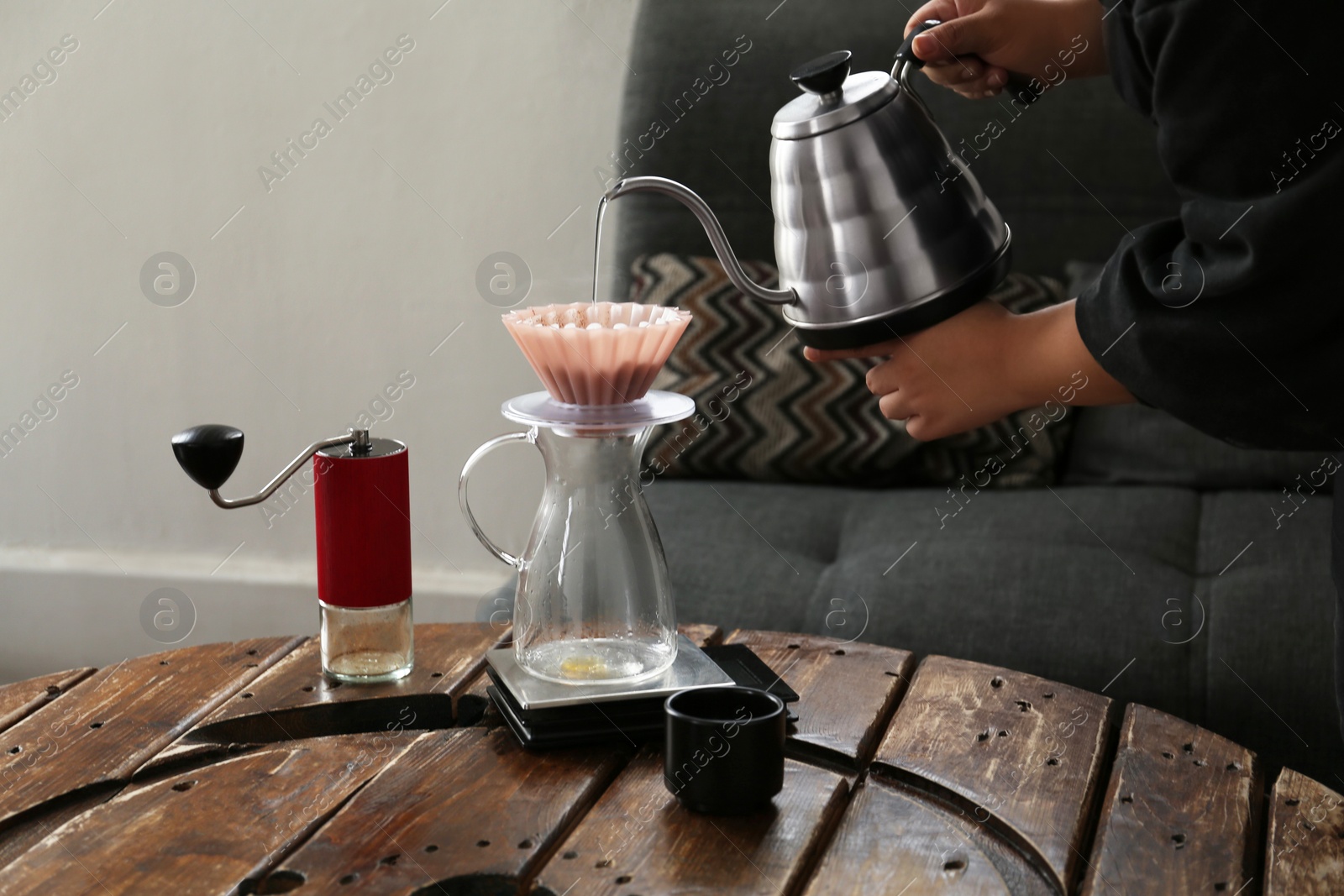 Photo of Barista preparing coffee at wooden table in cafe, closeup