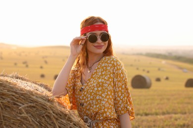 Photo of Happy hippie woman near hay bale in field