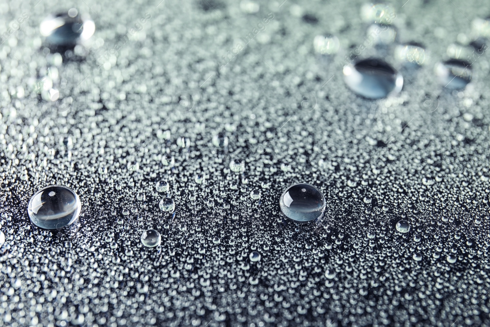Photo of Many clean water drops on dark background
