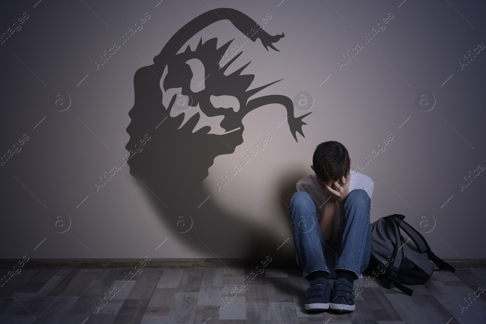 Image of Shadow of monster on wall and scared boy in room