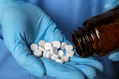 Photo of Doctor pouring pills from bottle onto hand, closeup view