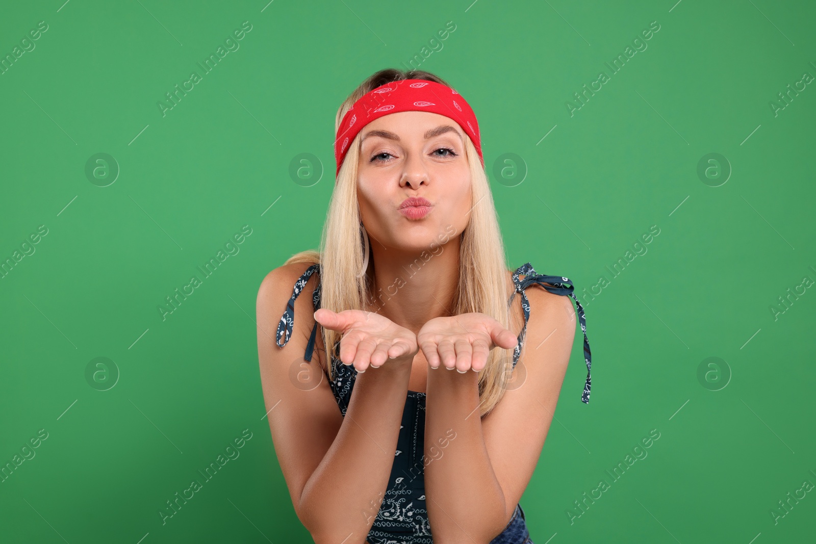 Photo of Portrait of beautiful hippie woman blowing kiss on green background