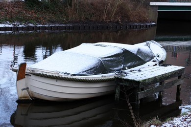 Water canal with moored boat on winter day