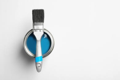 Photo of Paint can and brush on white background, top view. Space for text