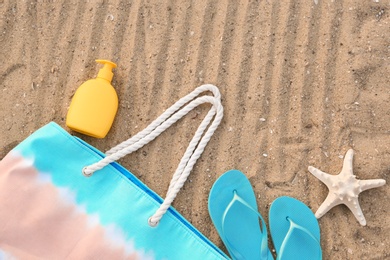 Composition with beach accessories on sand, flat lay. Space for text