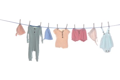 Photo of Colorful baby clothes drying on laundry line against white background