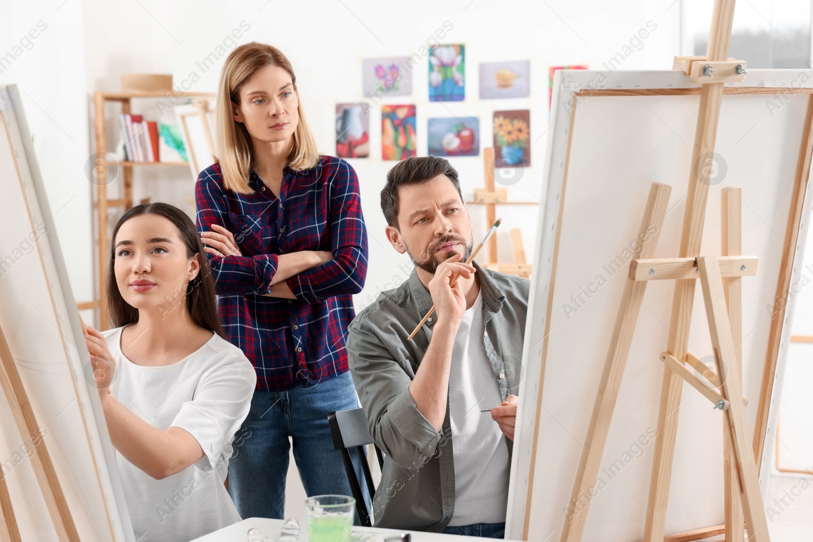 Photo of Artist teaching her students to paint in studio. Creative hobby