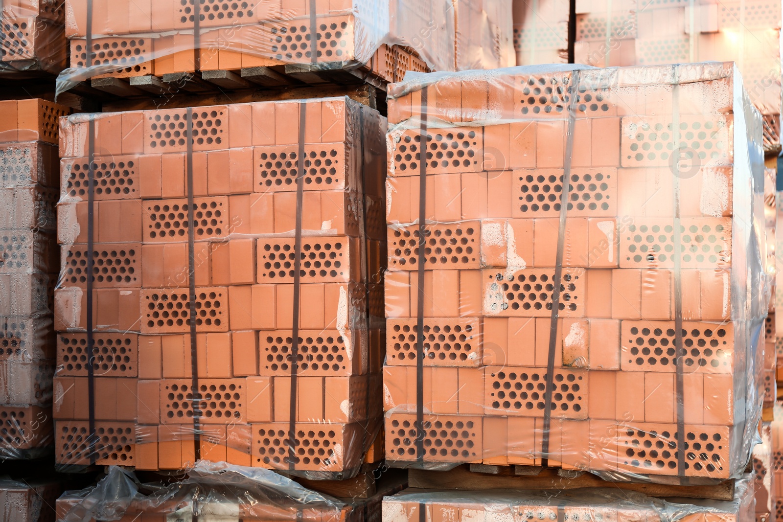 Photo of Pallets with red bricks outdoors. Building materials wholesale