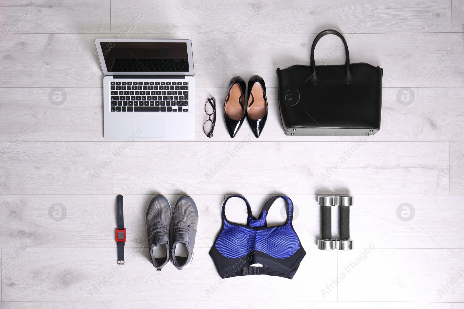 Photo of Flat lay composition of business items with sport accessories on white wooden background. Life and work balance concept