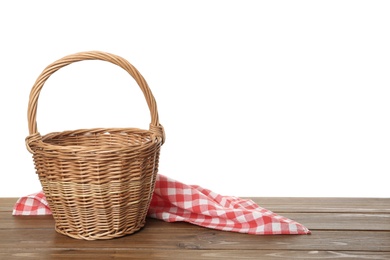 Photo of Empty wicker basket and cloth on wooden table against white background, space for text. Easter holiday