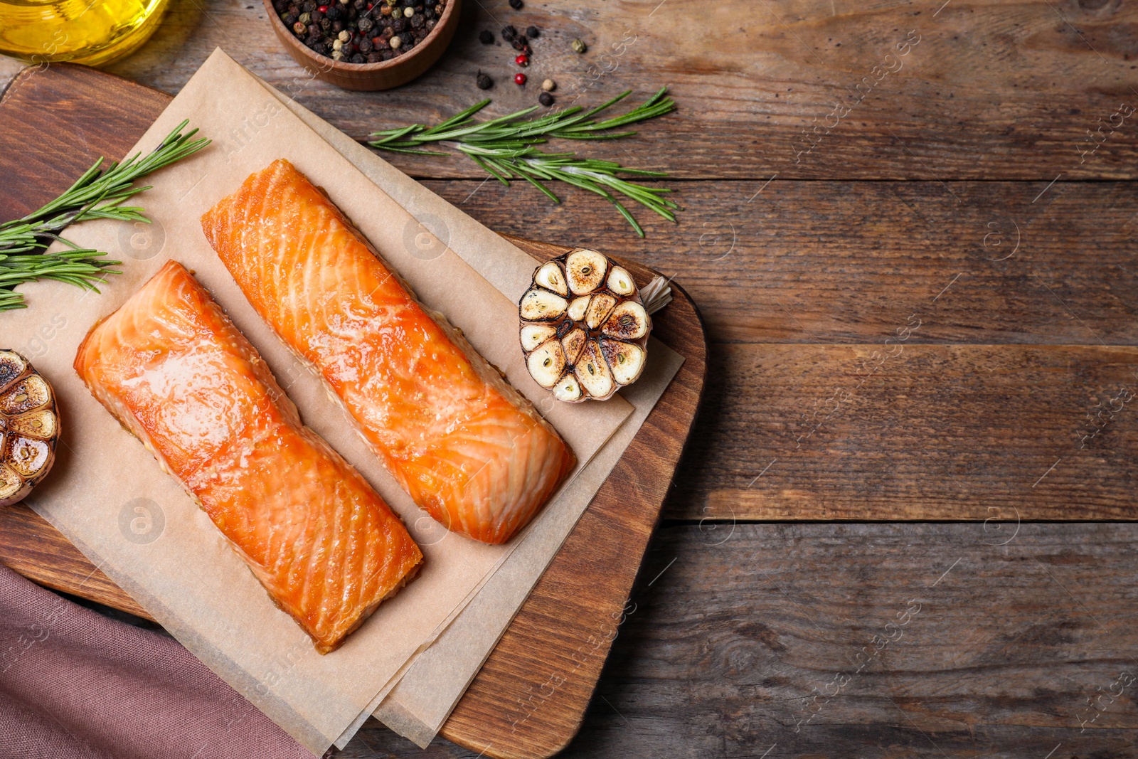 Photo of Delicious roasted fish on wooden table, flat lay. Space for text