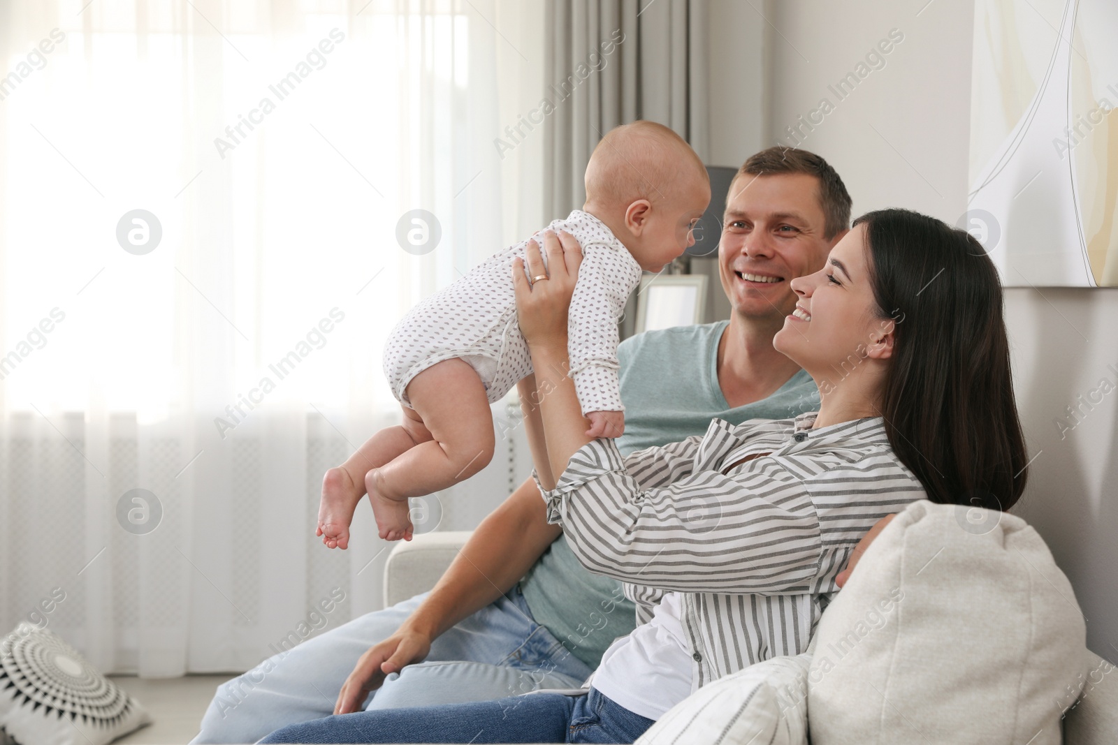 Photo of Happy family with their cute baby in living room at home