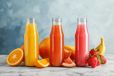 Bottles with tasty juices and ingredients on table