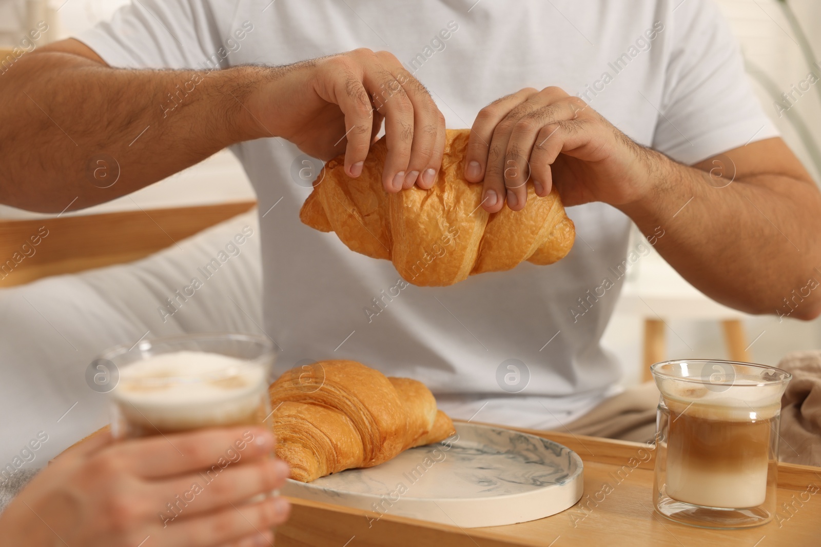 Photo of Couple having breakfast together on bed at home, closeup