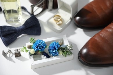 Wedding stuff. Composition with stylish boutonniere on white background, closeup