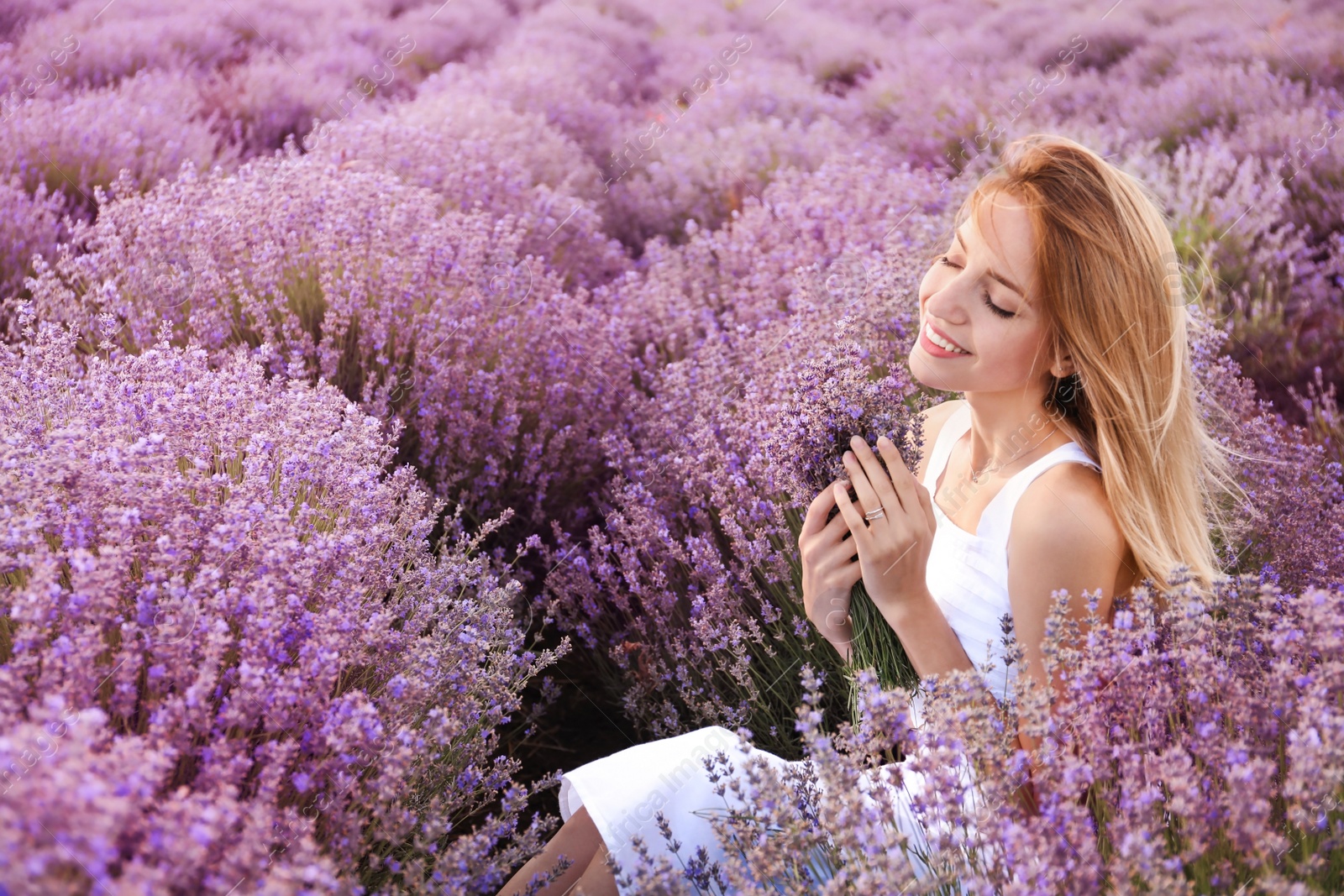 Photo of Young woman with bouquet in lavender field