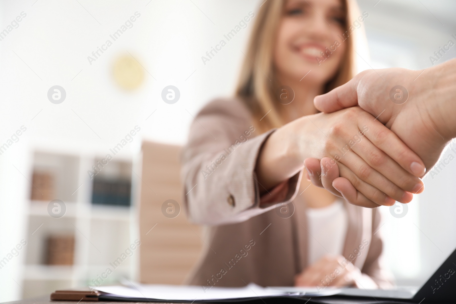 Photo of Business partners shaking hands at table after meeting, closeup. Space for text