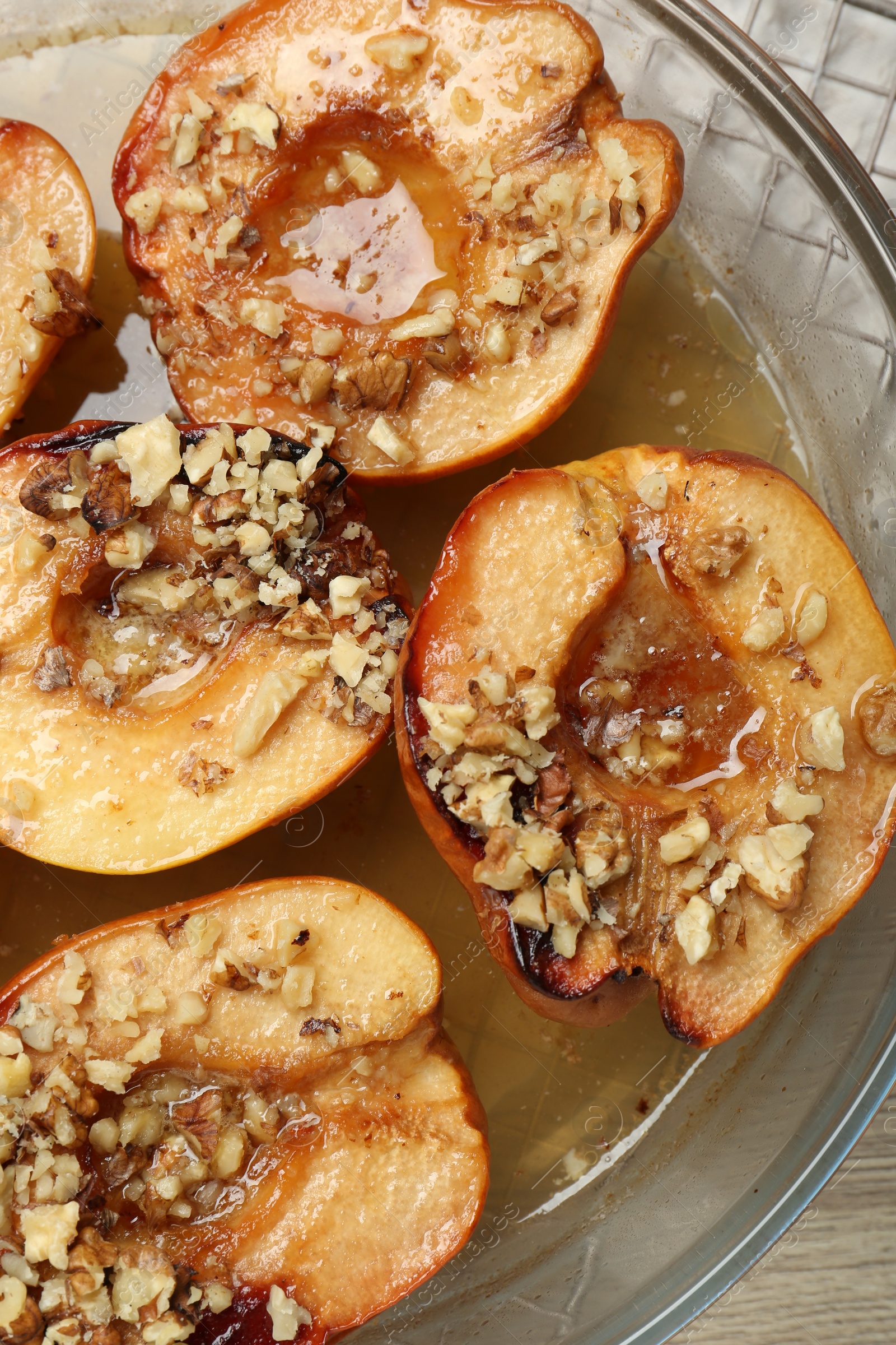 Photo of Delicious baked quinces with nuts and honey in bowl on table, top view