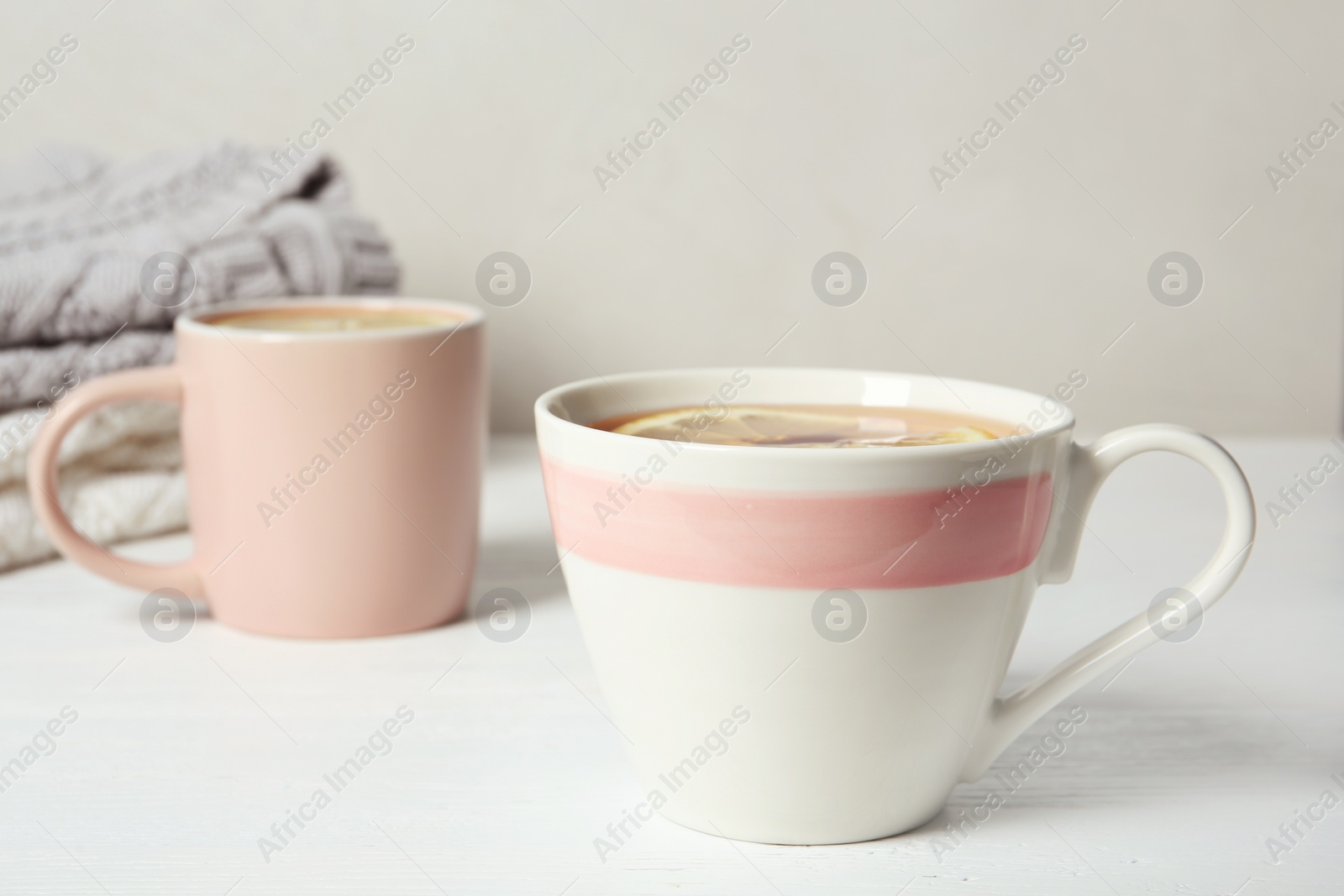 Photo of Cup of hot tea with lemon on white table