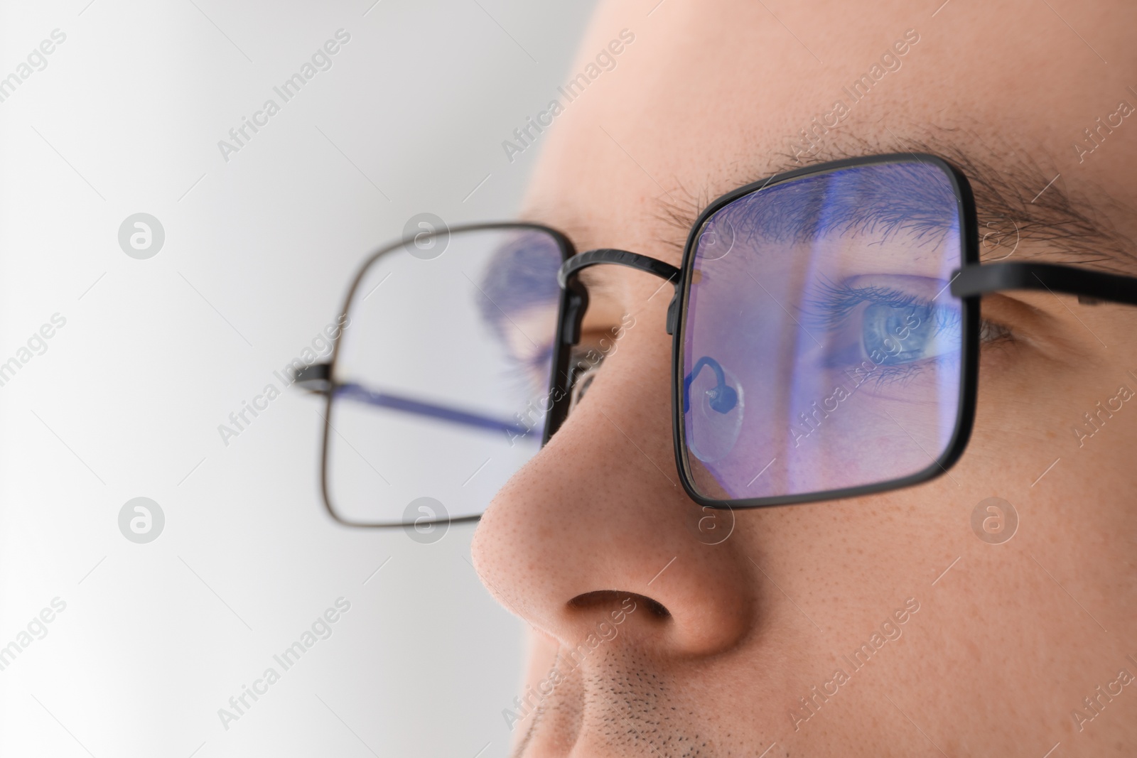 Photo of Man wearing glasses on light background, closeup