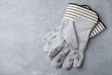 Pair of color gardening gloves on light grey table, top view. Space for text