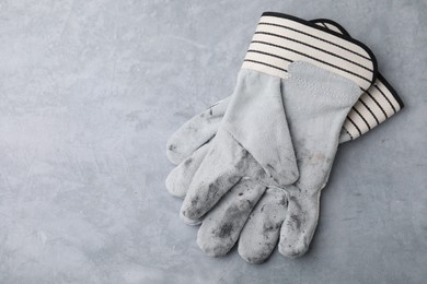 Photo of Pair of color gardening gloves on light grey table, top view. Space for text