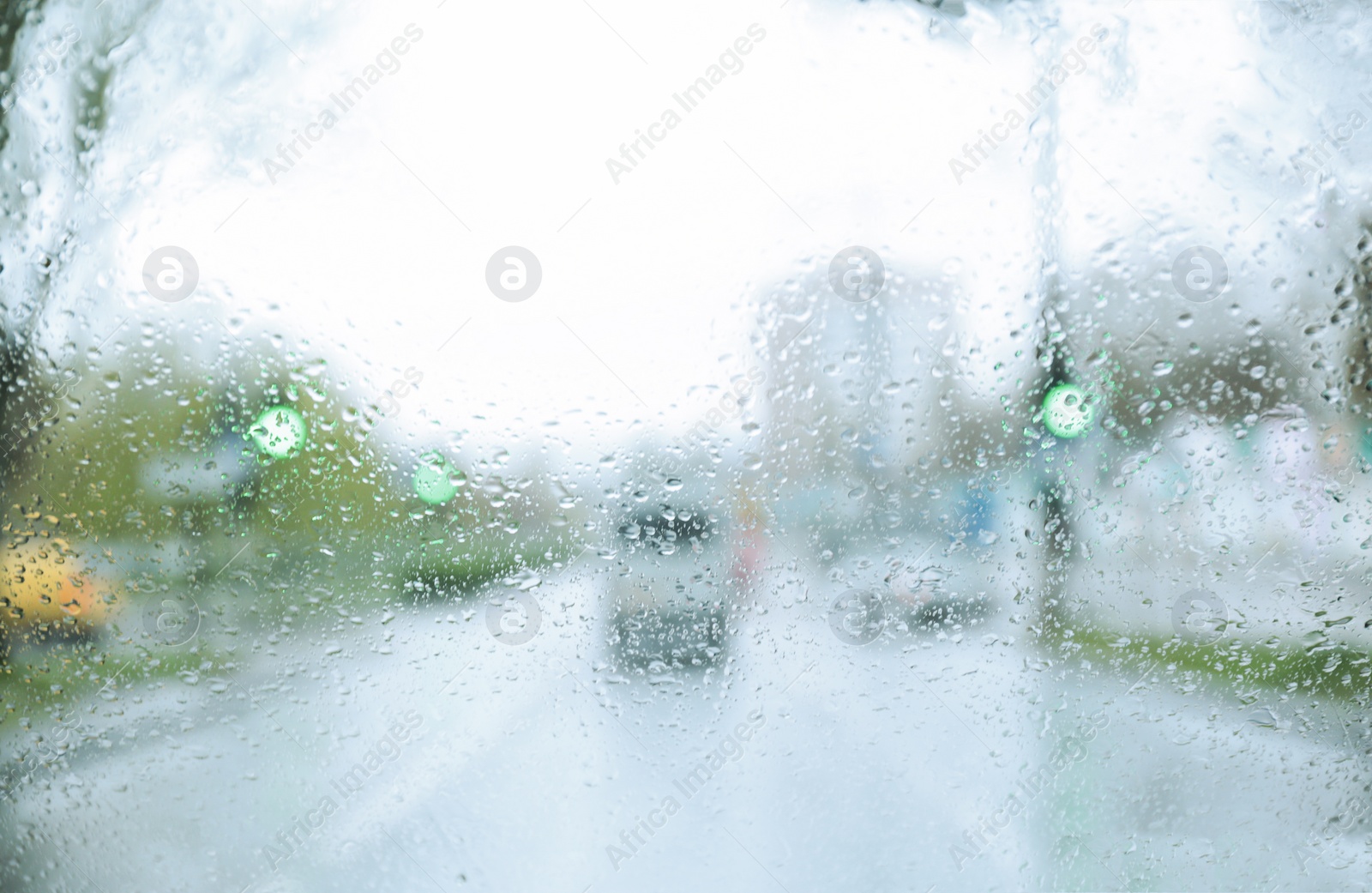 Photo of Blurred view of road through wet car window. Rainy weather