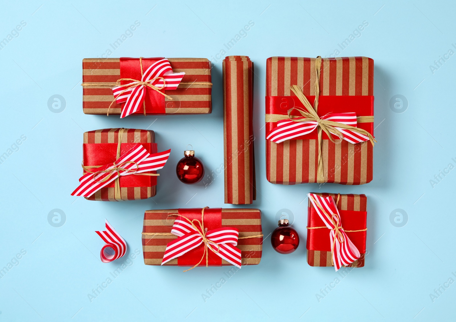 Photo of Gift boxes and Christmas balls on light blue background, flat lay