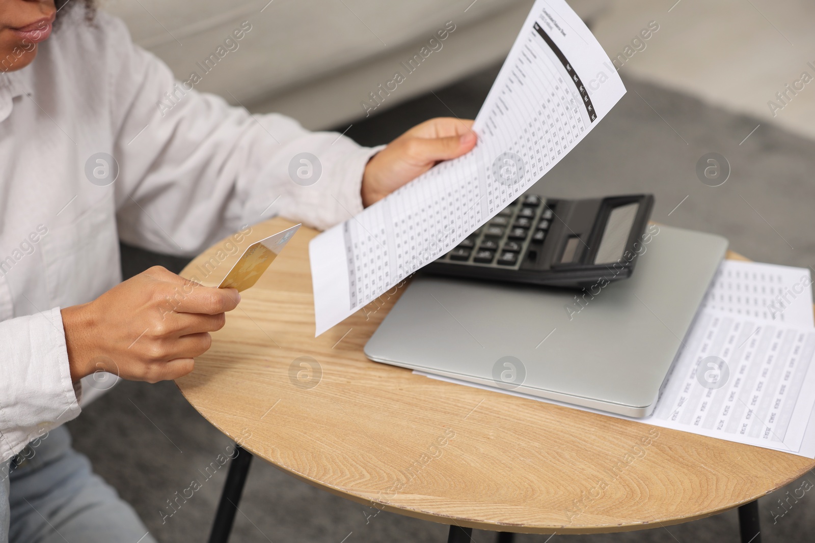 Photo of Woman with debt notification and credit card planning budget at table indoors, closeup.
Financial problem