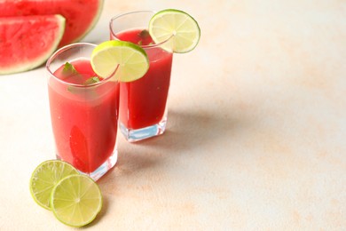 Tasty summer watermelon drink with lime in glasses on light table. Space for text
