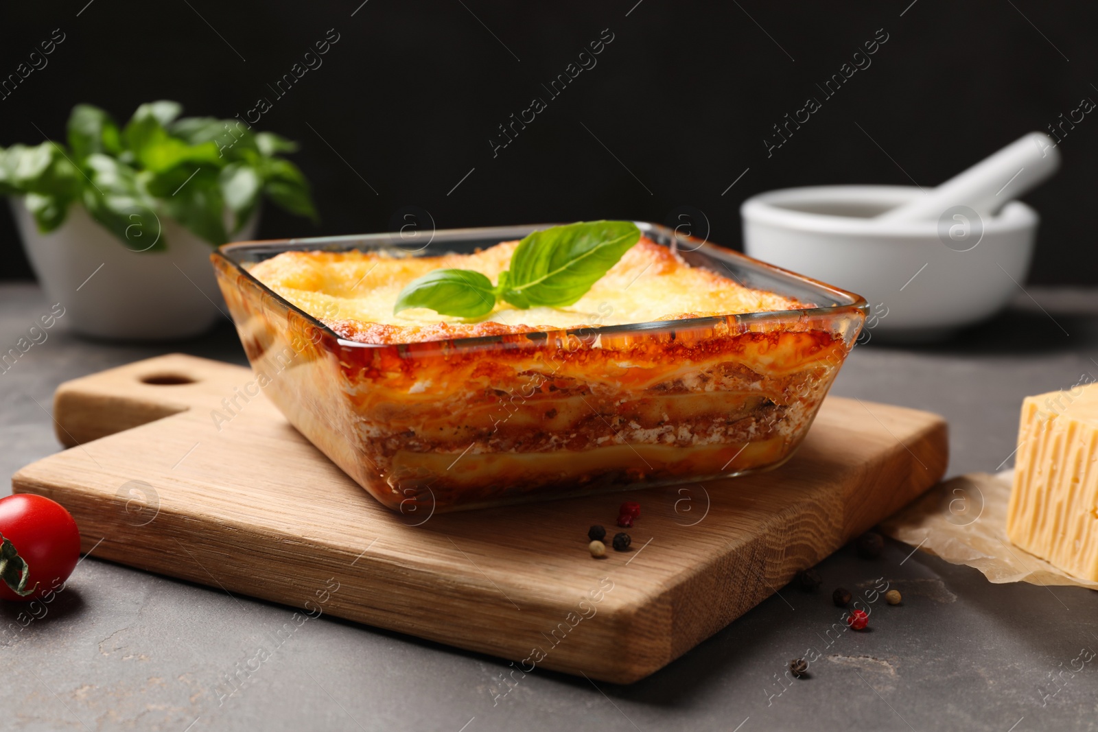 Photo of Tasty cooked lasagna in baking dish on grey table