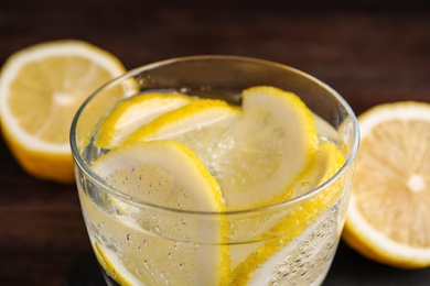 Photo of Fresh soda water with lemon slices, closeup