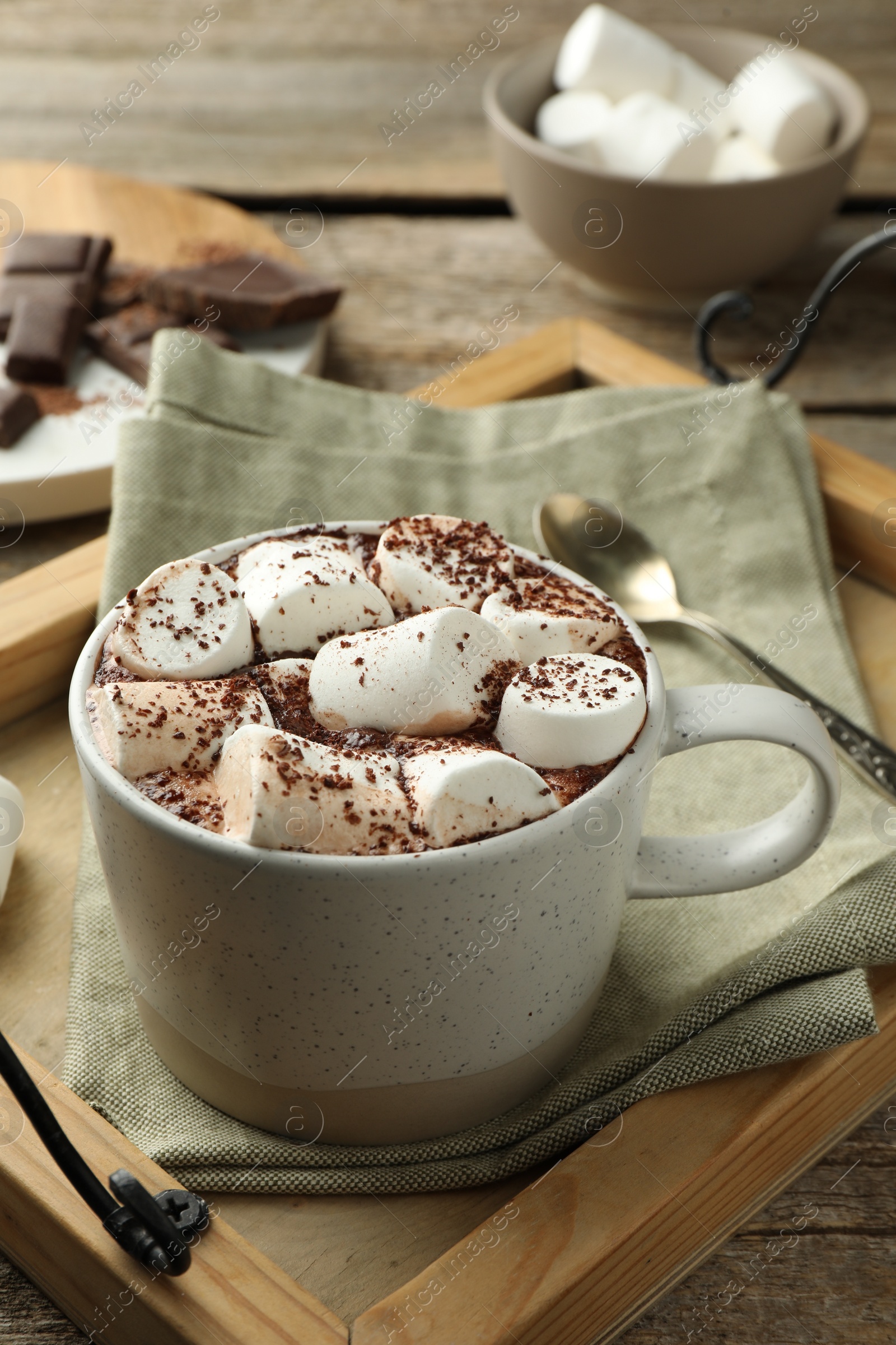 Photo of Delicious hot chocolate with marshmallows and cocoa powder on wooden table