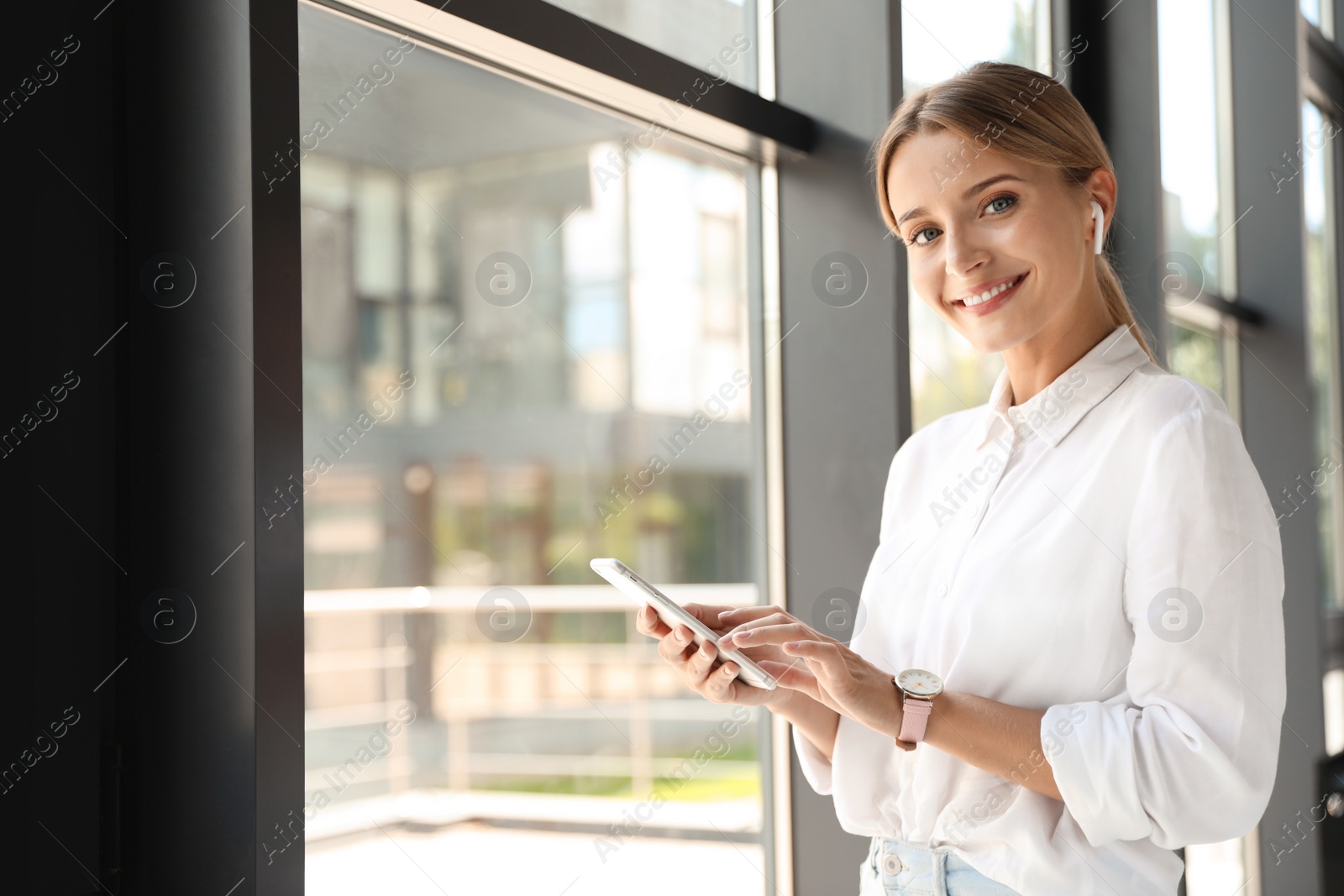 Photo of Portrait of female business trainer with smartphone indoors