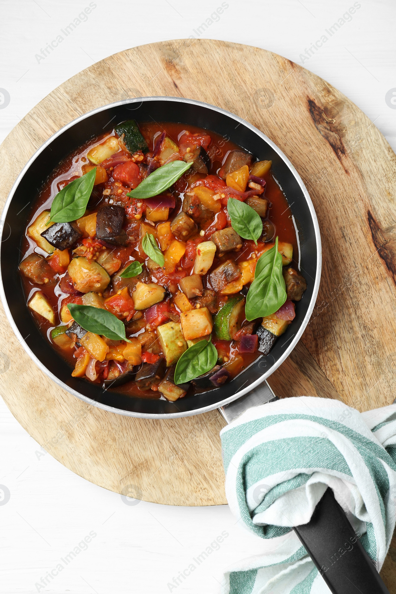 Photo of Frying pan with tasty ratatouille on white wooden table, top view